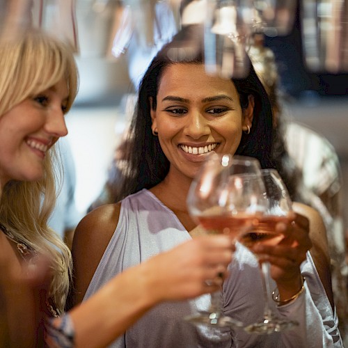 A group of women enjoying drinks and each other's company at a lively social gathering.