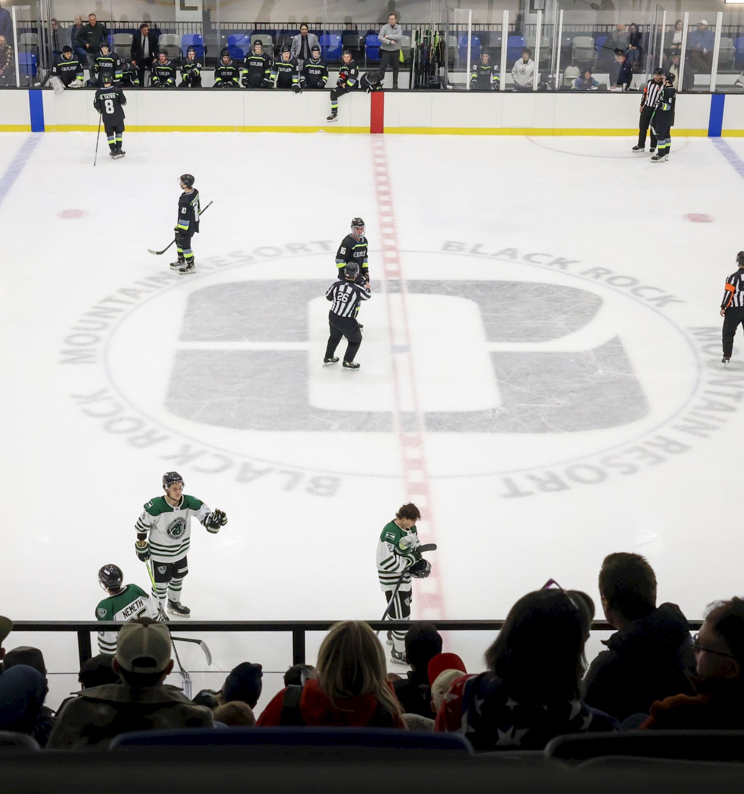 A hockey game is about to start at Blackrock Mountain Resort, with players on ice and spectators watching.